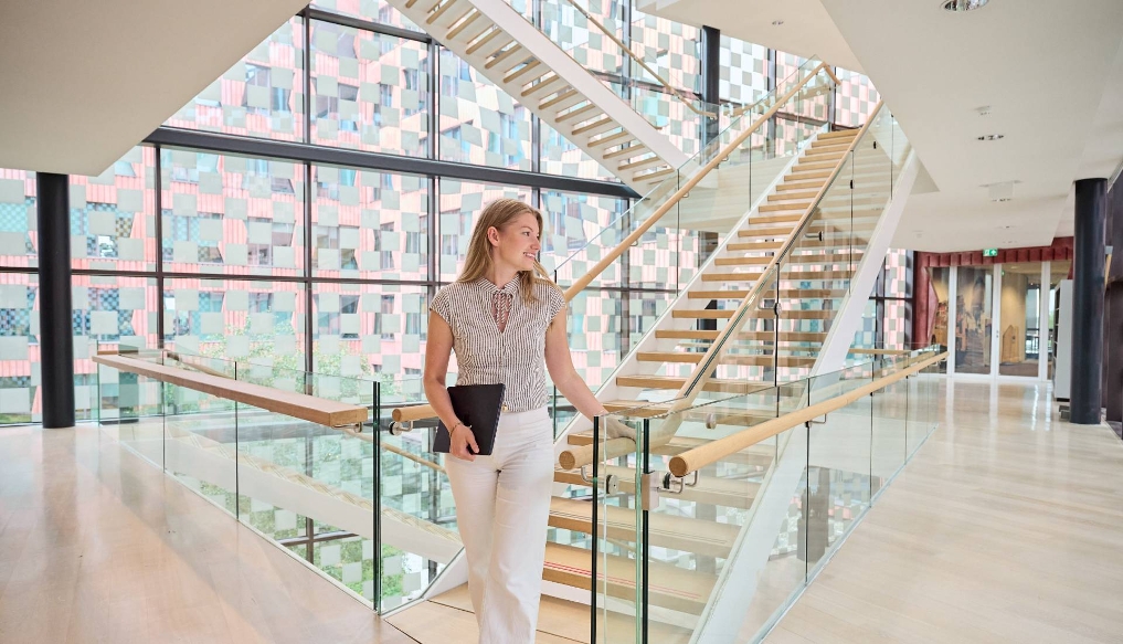 Cloë, AI-specialist bij het CBS, loopt de trap af in het gebouw waar zij werkt
