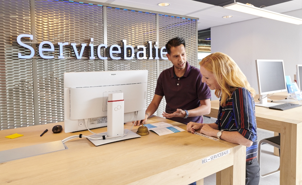 Susan en haar collega staan te praten bij de servicebalie