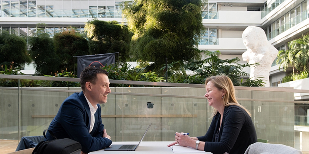 Wouter en een collega zitten in de binnentuin van het ministerie van Financiën