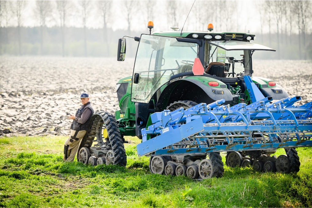 Een medewerker van Stichting Exploitatie Reservegronden Flevoland leunt tegen een trekker