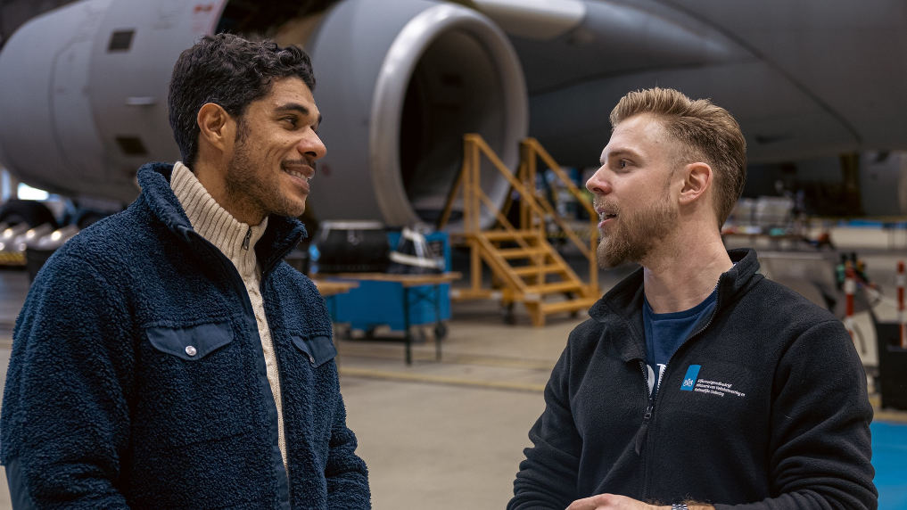 Rik, bouwkundig inspecteur bij het Rijksvasrgoedbedrijf vertelt over zijn indrukwekkende werkomgeving, voor een groot transporttoestel.