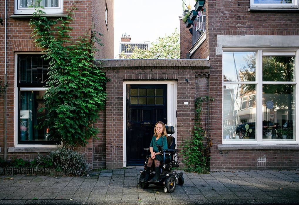 Anne de Ruijter in haar rolstoel buiten bij haar huis