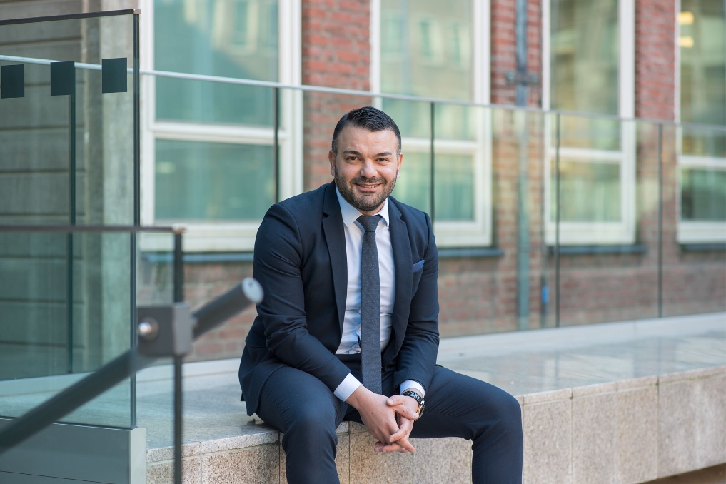 Portret van Ilkay. Hij is senior beleidsmedewerker bij het ministerie van EZK