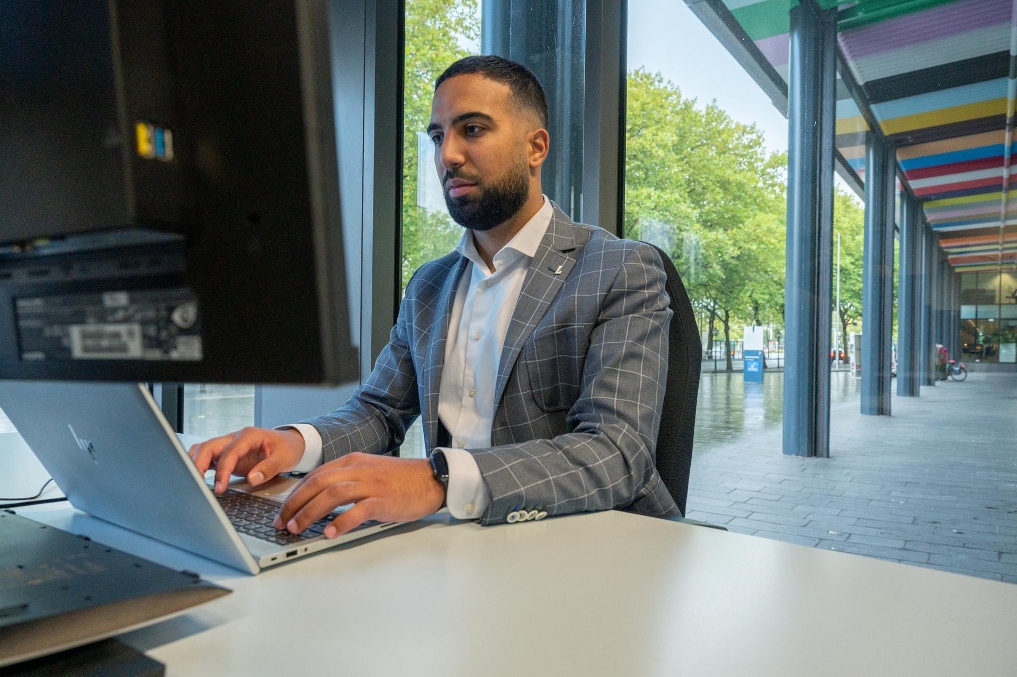 Oussama op kantoor bij de Auditdienst Rijk achter de computer aan het werk