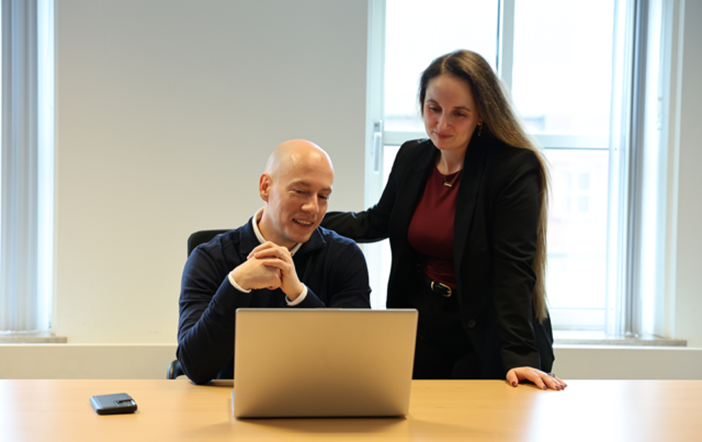 Manon en Dave kijken naar het scherm van een laptop