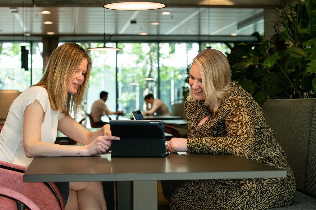 Michelle Kroon is IT-auditor bij de ADR en zit samen met een vrouwelijke collega aan een tafel in het gebouw van het ministerie van Financiën