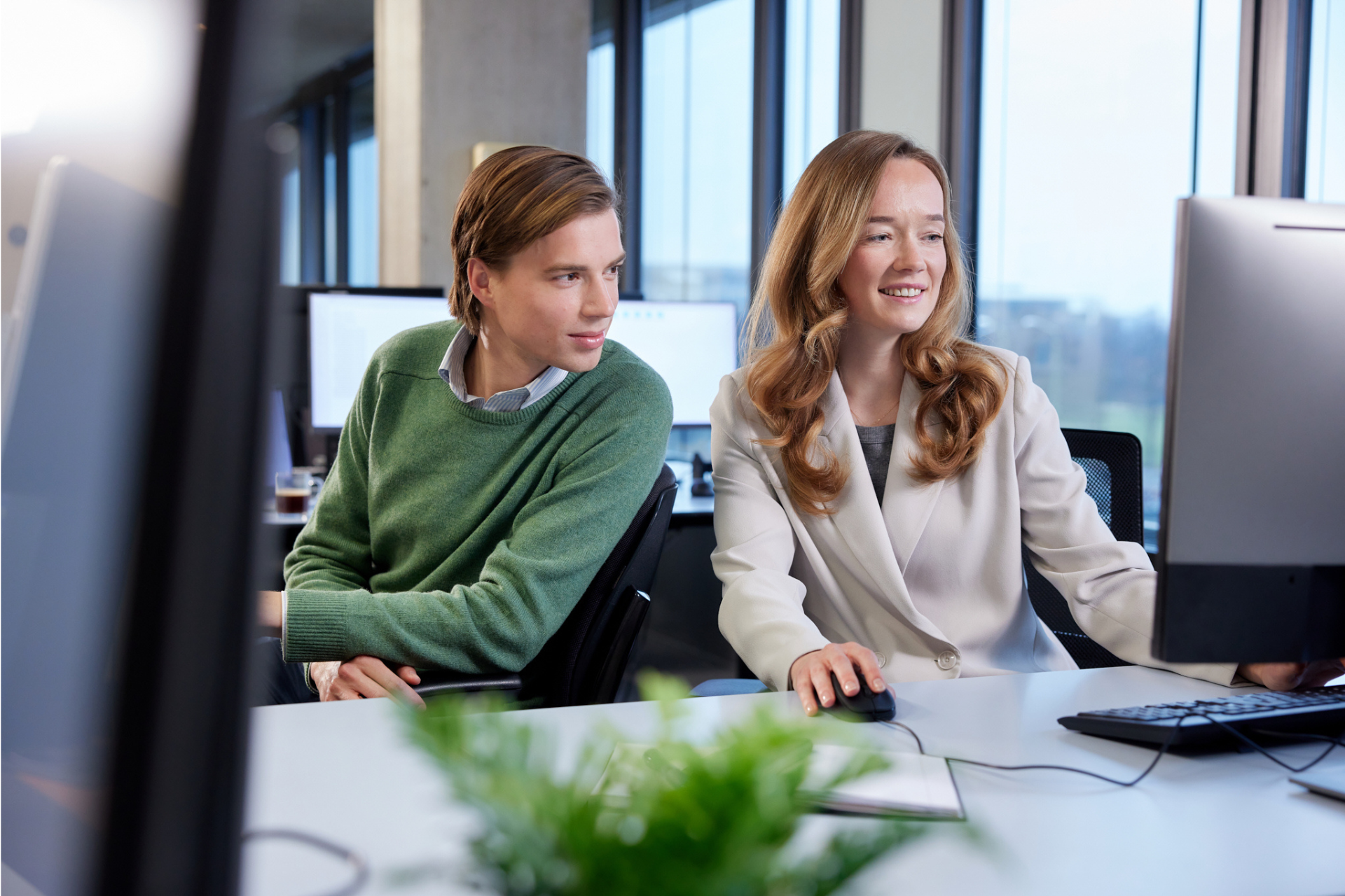 2 collega's bij het ministerie van Financiën samen achter de laptop. Ontdek onze expertises
