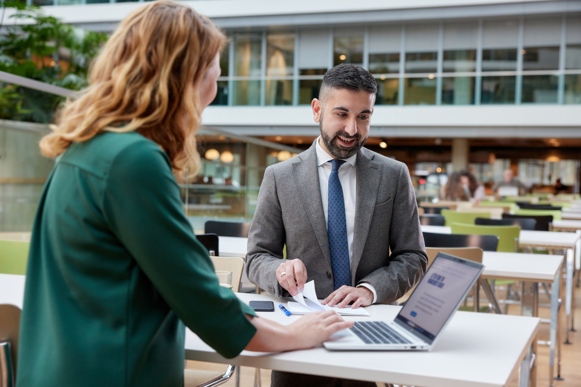2 collega's bij het ministerie van Financiën in gesprek bij een statafel