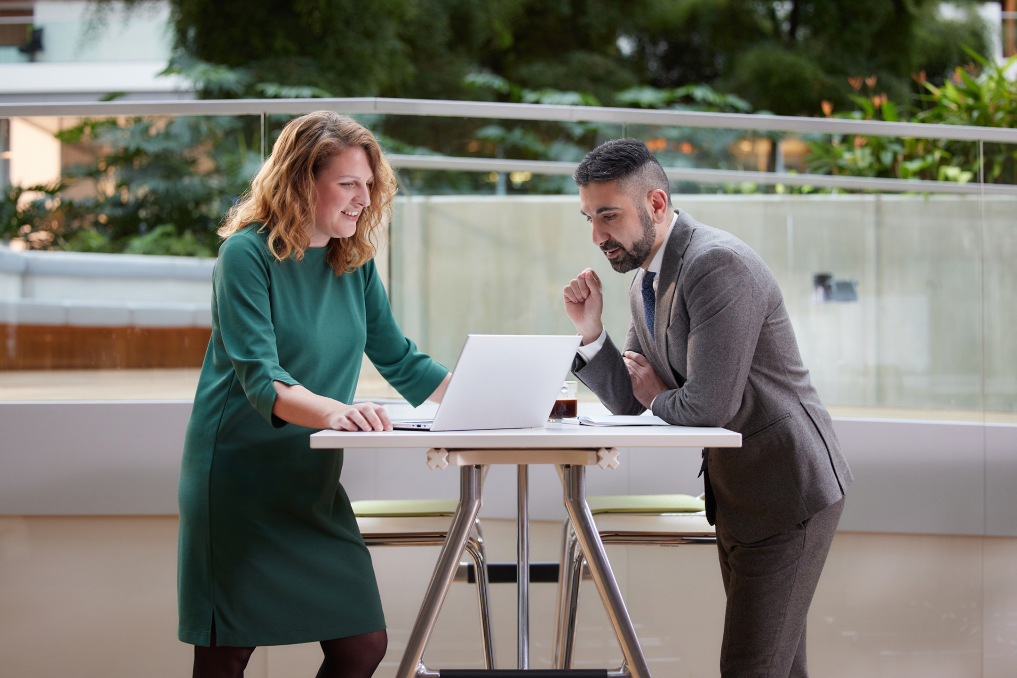 2 collega's bij het ministerie van Financiën, overleggend aan een statafel