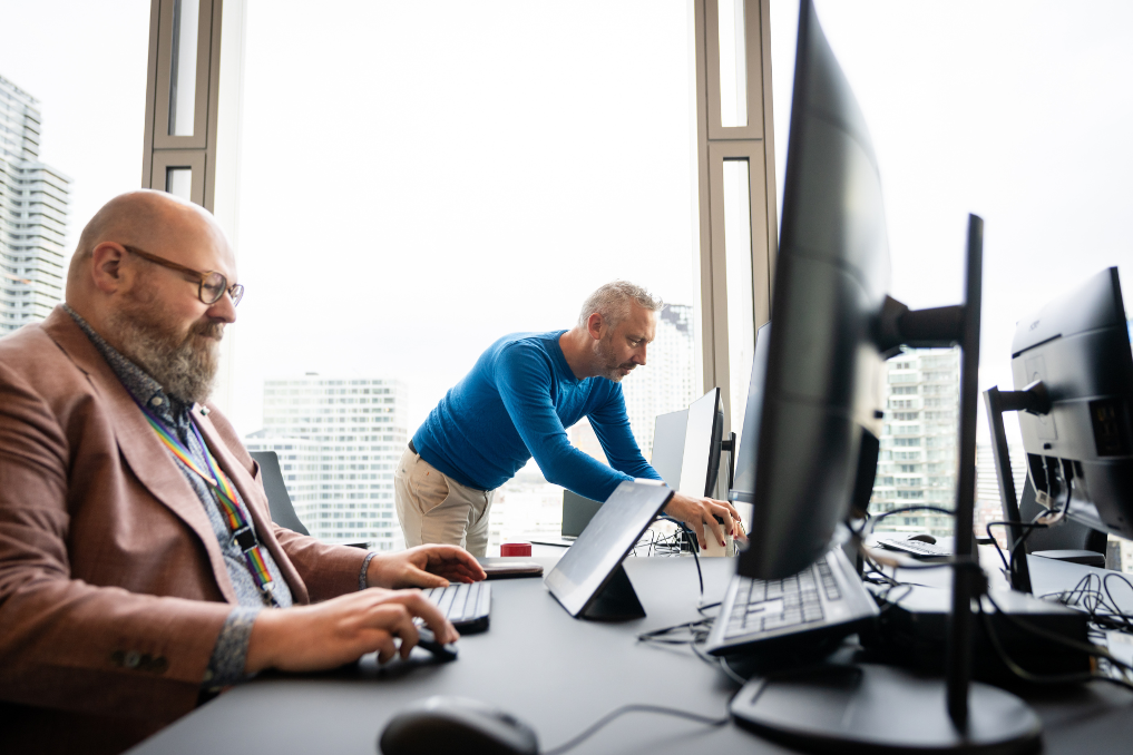 2 collega's achter de laptop bij de ILT. Zij werken in IT, data en analyse