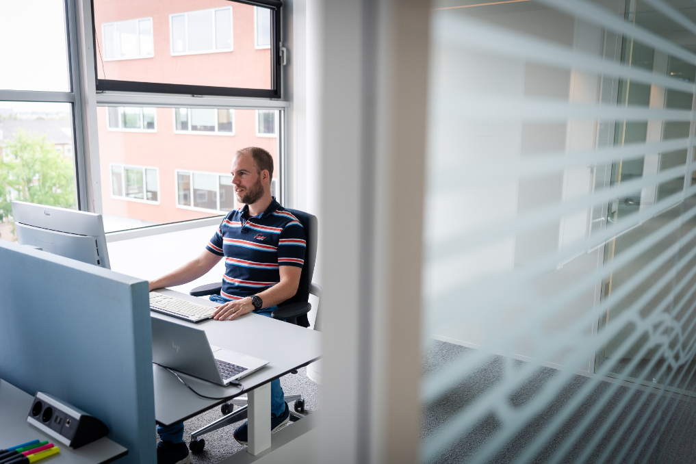 Collega bij de ILT achter laptop. Hij werkt in IT, data en analyse