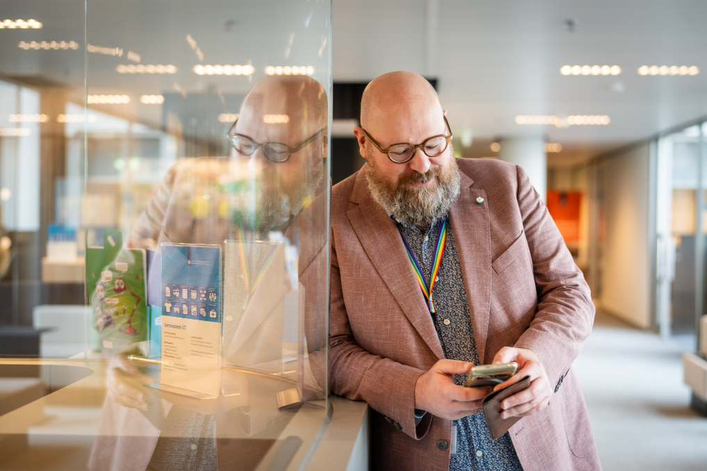 Portret van collega bij de ILT met mobiel Hij werkt in IT, data en analyse