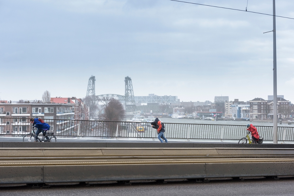 voetgangers op een brug bij harde wind