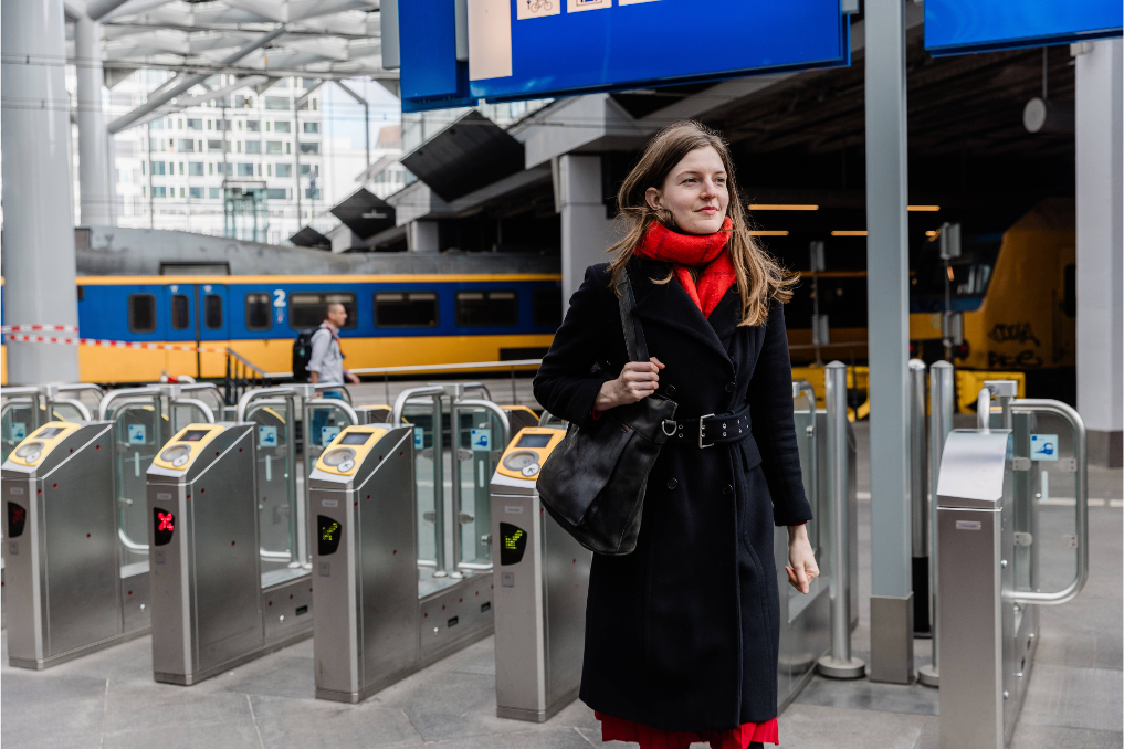 Een collega van het ministerie van IenW loopt bij de uitgangspoortjes van CS Den Haag