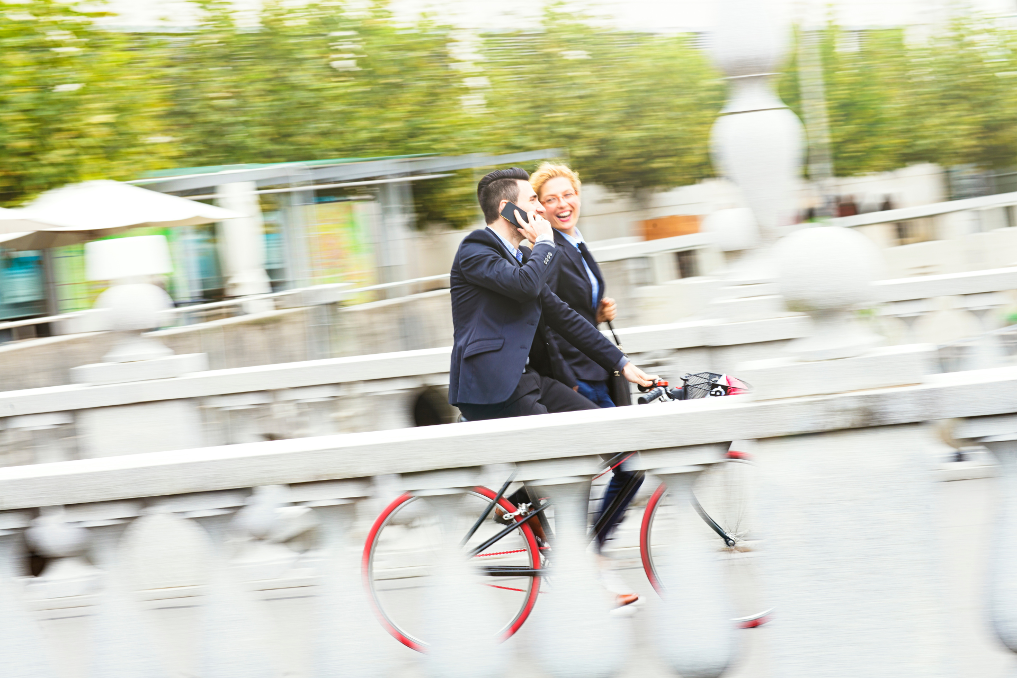 2 fietsers, waarvan 1 met een mobiele telefoon