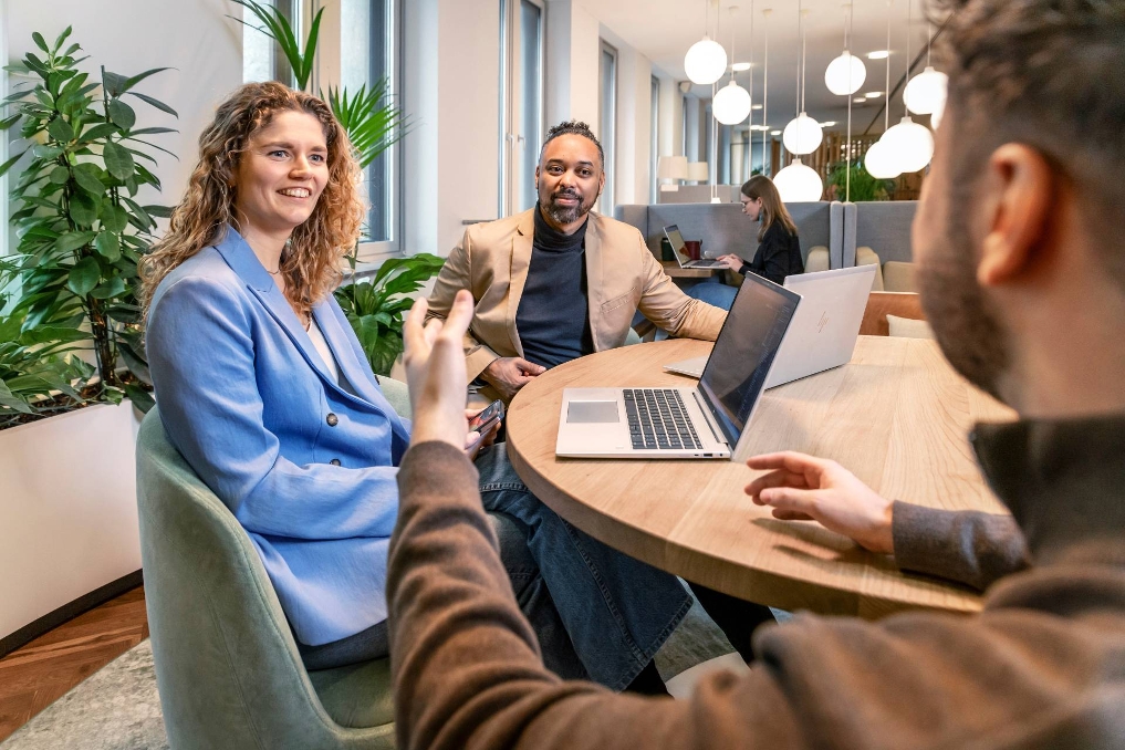 Martha, lead data scientist bij JenV, aan tafel in gesprek met collega's