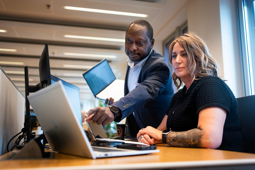 2 collega-juristen bij Justitie en Veiligheid in overleg achter de laptop
