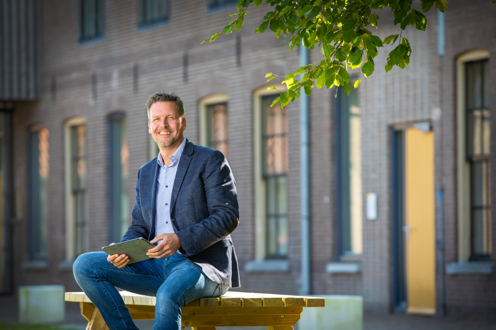 Bob zit op een bankje met een I-Pad in zijn hand