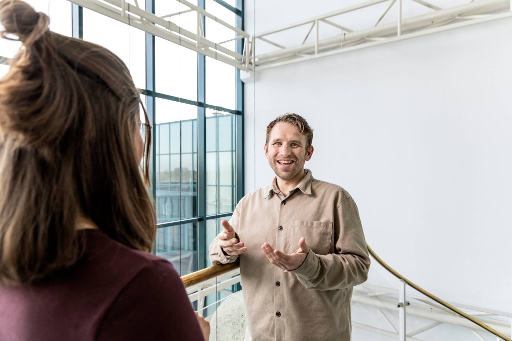Dusty, testconsultant bij de Justitiële ICT Organisatie, in gesprek met een collega