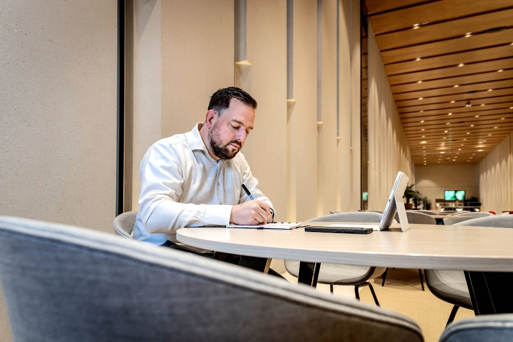 Sam aan het werk op zijn laptop. Hij is productmanager kwaliteit bij het Nederlands Forensisch Instituut