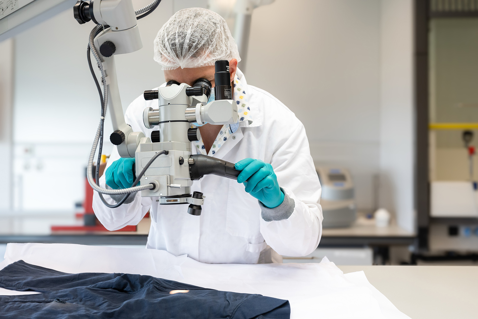 Medewerker van het NFI doet sporenonderzoek in het laboratorium