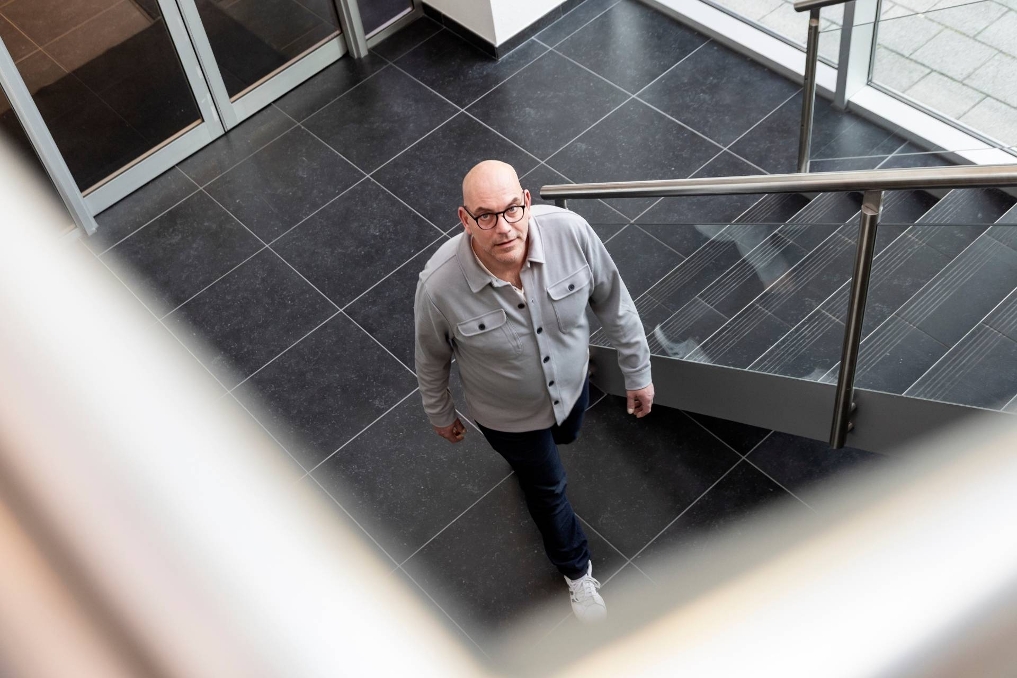 Michael loopt de trap op. Hij is teammanager van de product owners bij het Openbaar Ministerie (OM)