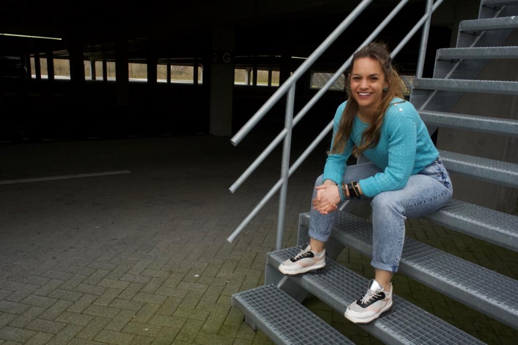 Boukeline zit op een traptrede van een stalen trap buiten