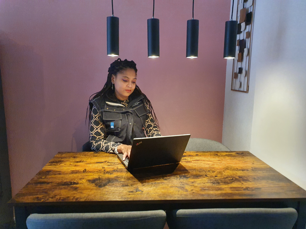 Charissa achter een laptop aan tafel