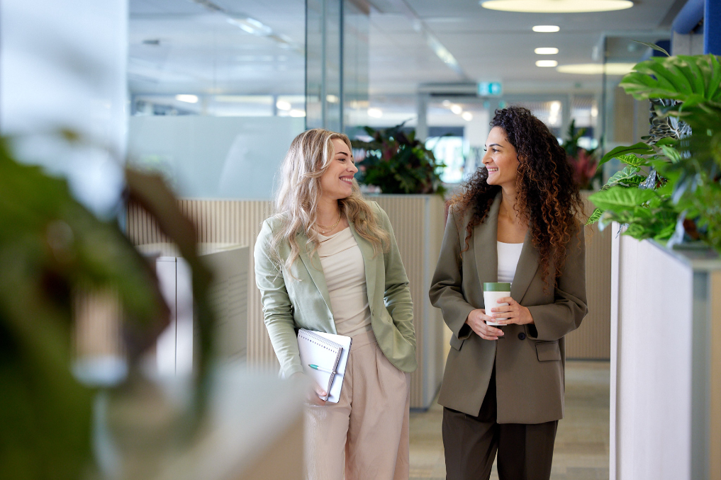 Anahita loopt met een collega door de gang. Anahita is manager bij de NVWA