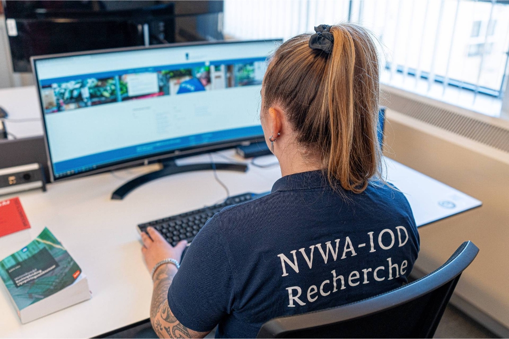 Rechercheur bij de NVWA-IOD achter het scherm. Ze krijgt een melding binnen