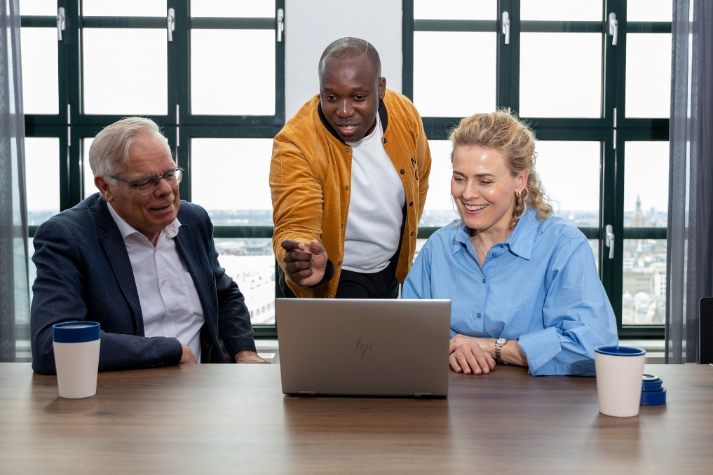 3 medewerkers kijken naar een laptopscherm