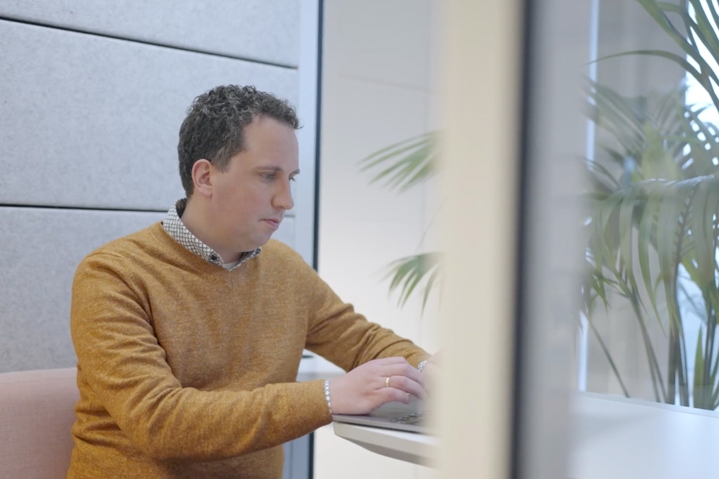 Laurens aan het werk achter zijn bureau. Hij werkt via de banenafspraak bij VWS