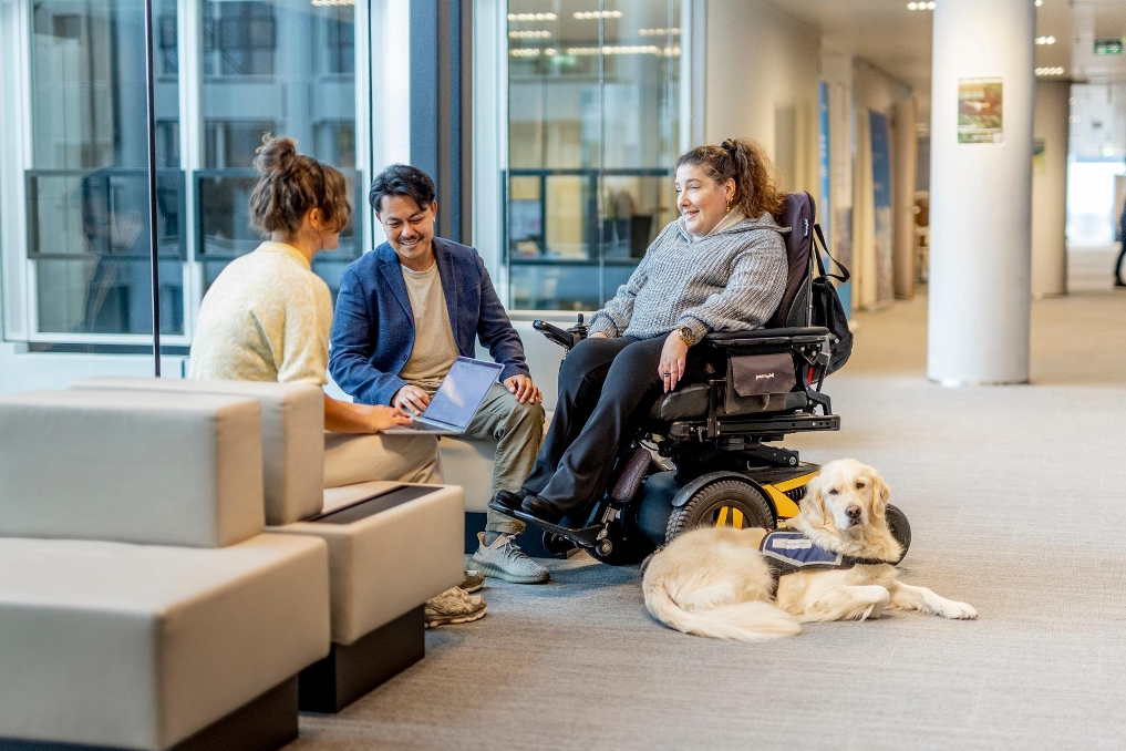 Vrouw in rolstoel met hulphond