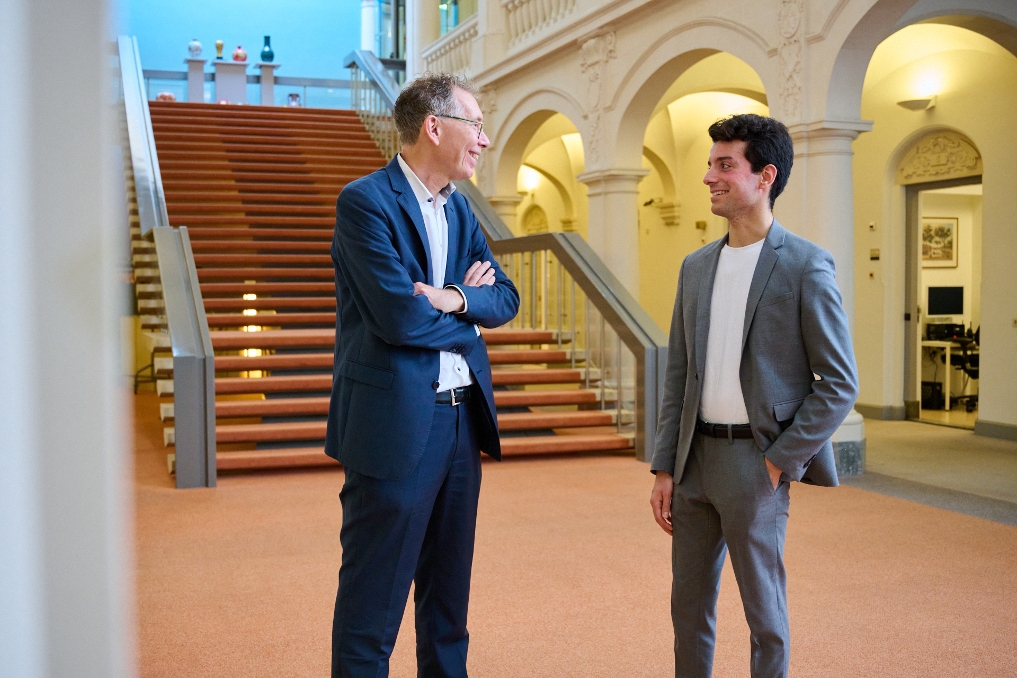 Mikail Sevik, financial trainee in gesprek met een collega in de hal van het ministerie van Algemene Zaken