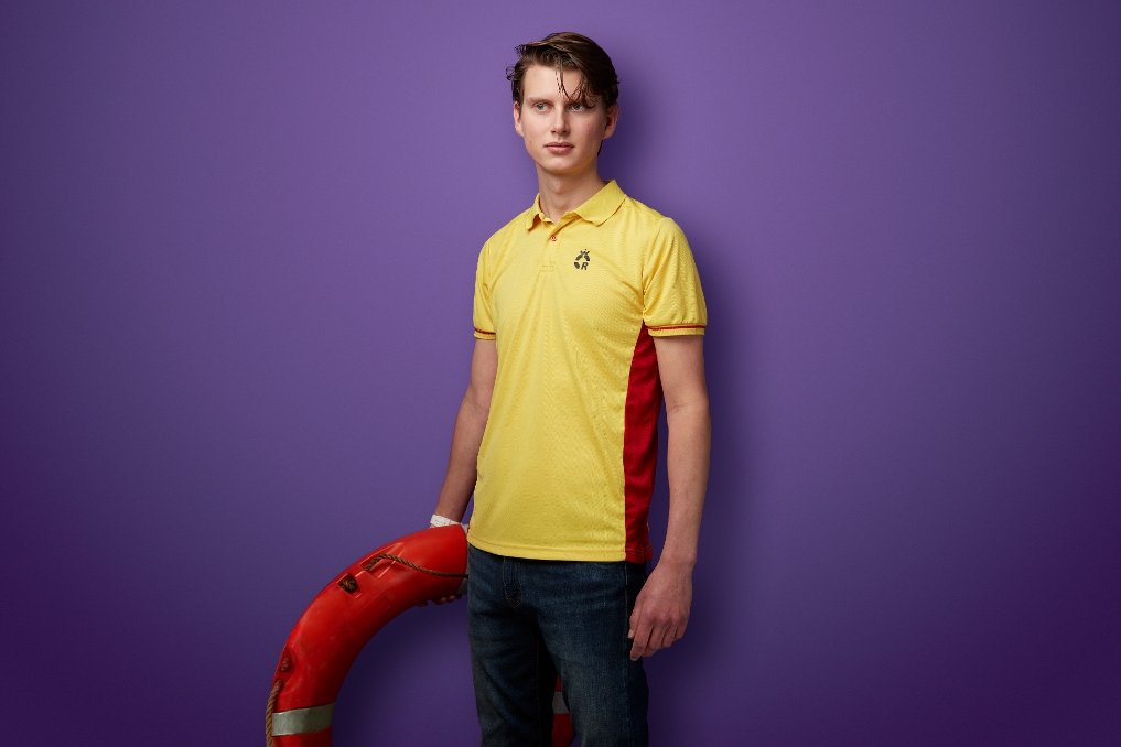 Portret rijkstrainee Olaf Smit staat in tenue van reddingsbrigade met in zijn hand een reddingsboei