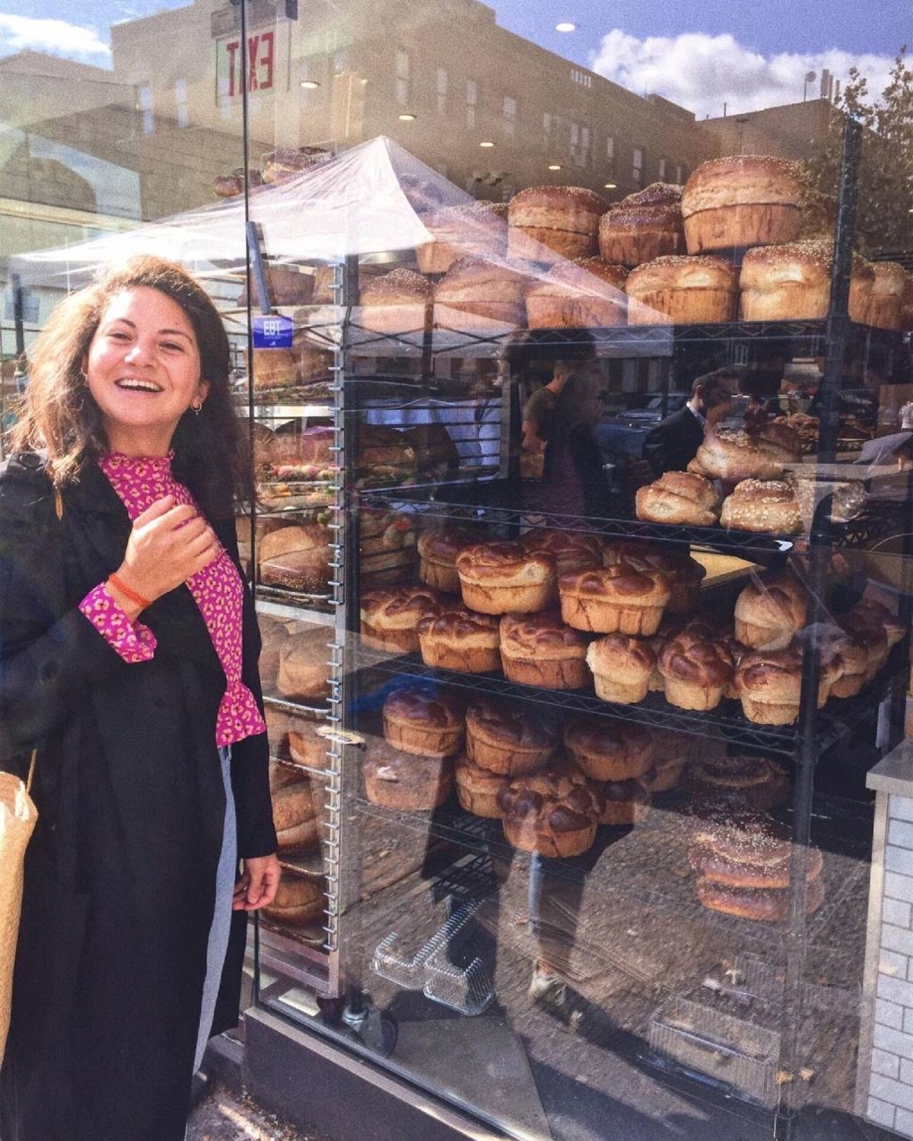 foto van Dina Sabi staand voor een kraampje met brood op de markt in Beiroet