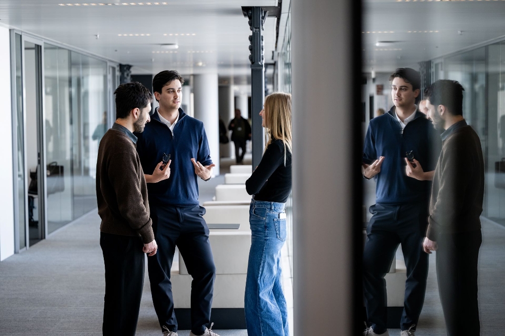 Trainee Sander is met mede-trainees op de gang in gesprek