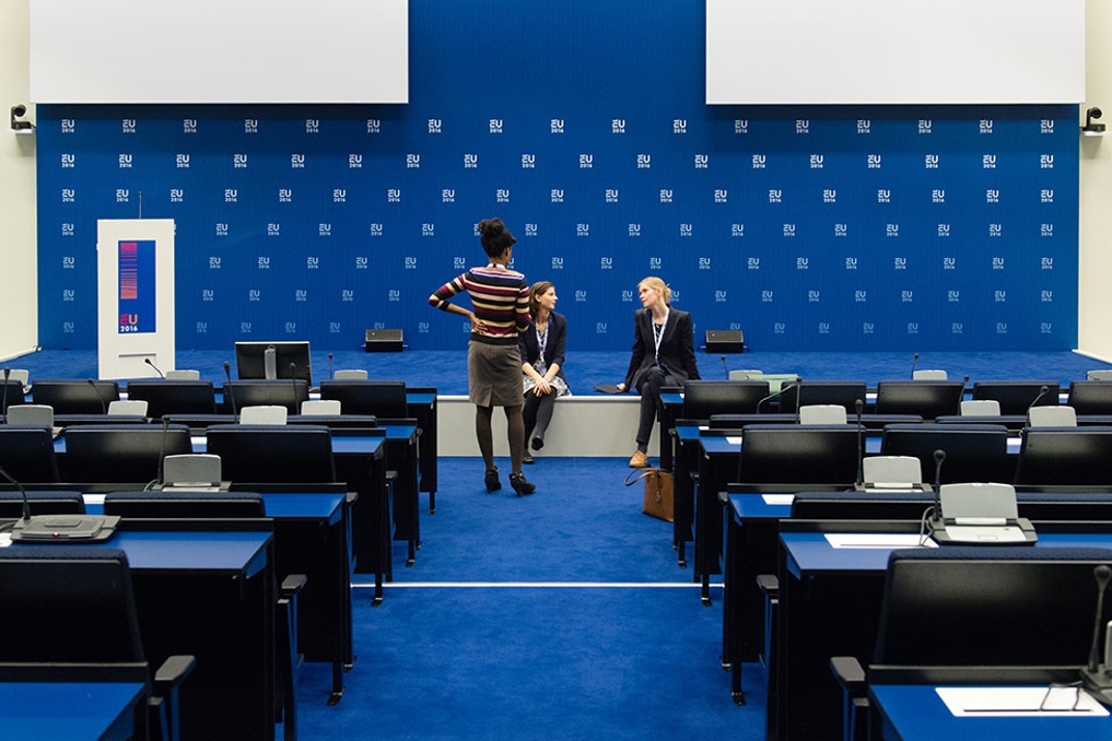 Zinzi, Nathalie en Andrea in gesprek in een conferentie zaal.