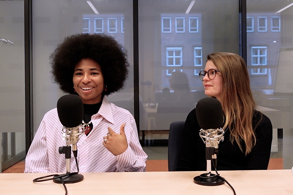 twee vrouwen met microfoons in een podcaststudio