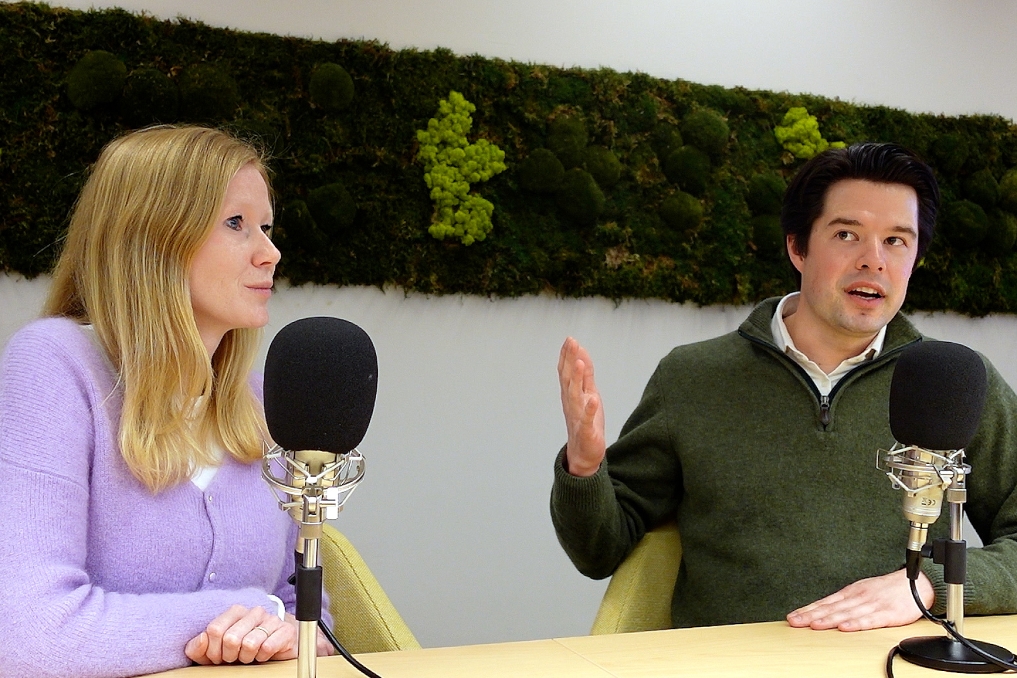 man en vrouw met twee microfoons in een podcaststudio