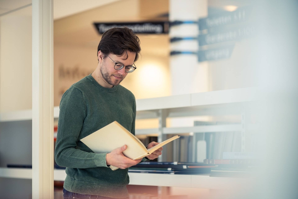 Max Muller, onderzoeker bij het Nationaal Archief praat met collega over promoveren