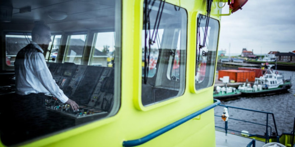 Kapitein Florus kijkt vanuit zijn kajuit naar buiten.