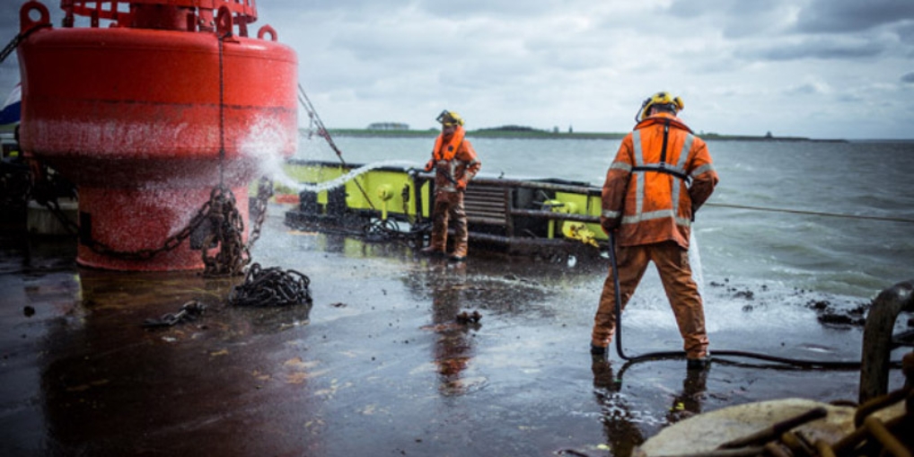 Aan het werk op het dek: schoonspuiten van materiaal.