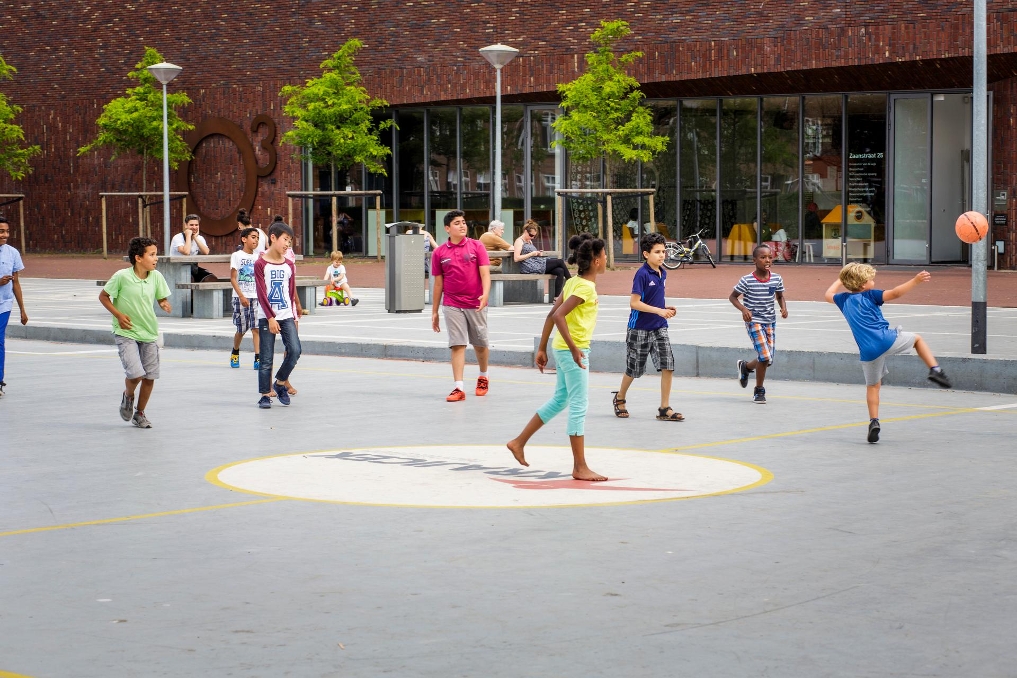 Kinderen voetballen op een schoolplein